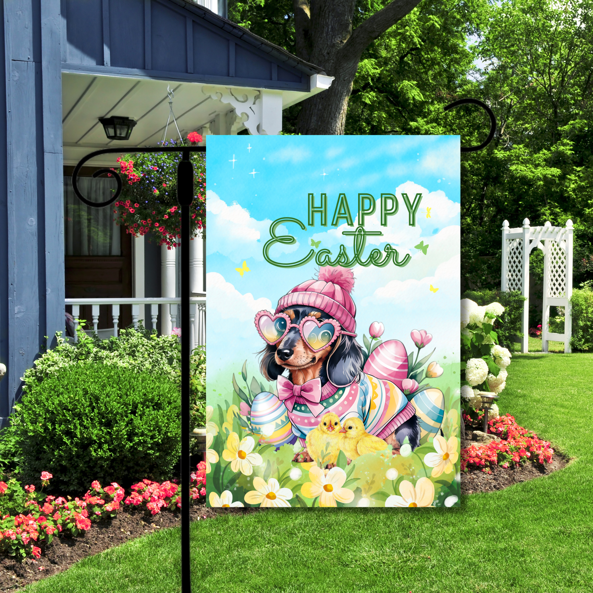 Decorative garden flag with Easter design featuring a dog, chicks, and flowers on a flagpole in front of a house.