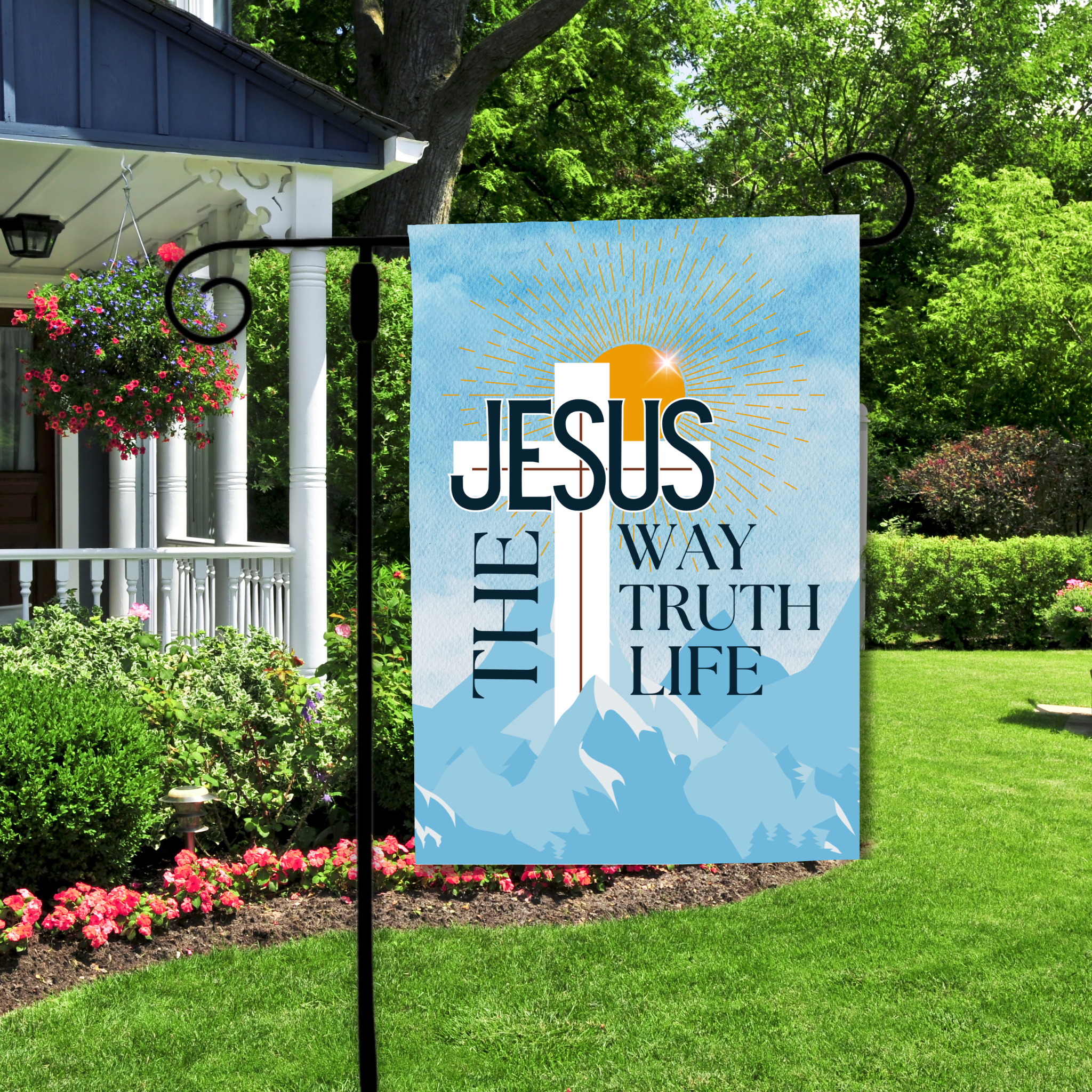 Decorative garden flag with 'Jesus The Way Truth Life' text in a garden setting.