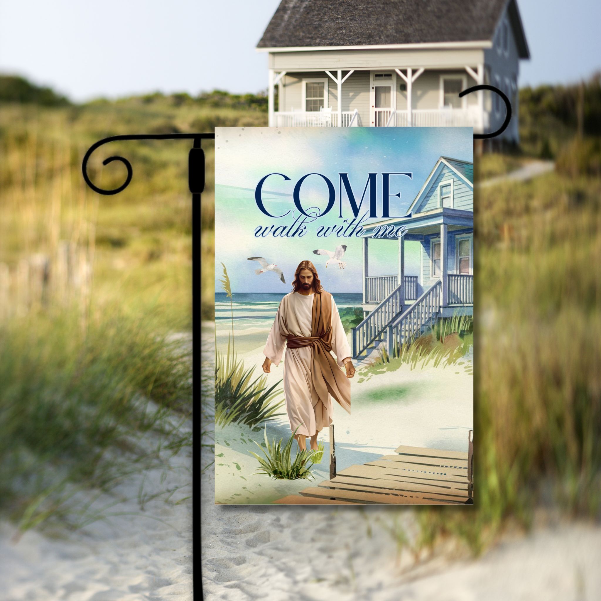 Decorative flag with a beach scene and text 'Come walk with me' in front of a house on a beach.