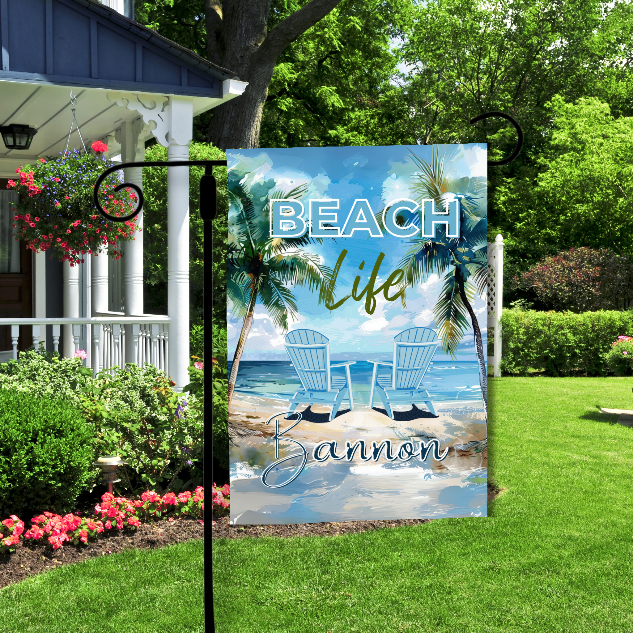 Decorative garden flag with 'Beach Life' design in a garden setting.