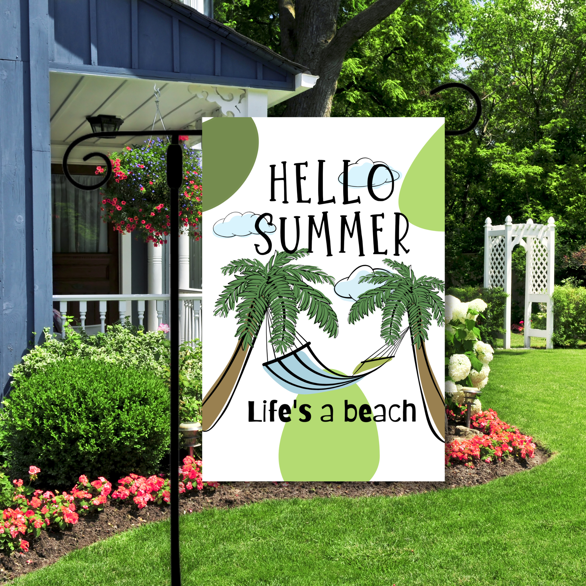 Decorative sign with 'Hello Summer, Life's a Beach' text and palm tree design in a garden setting.