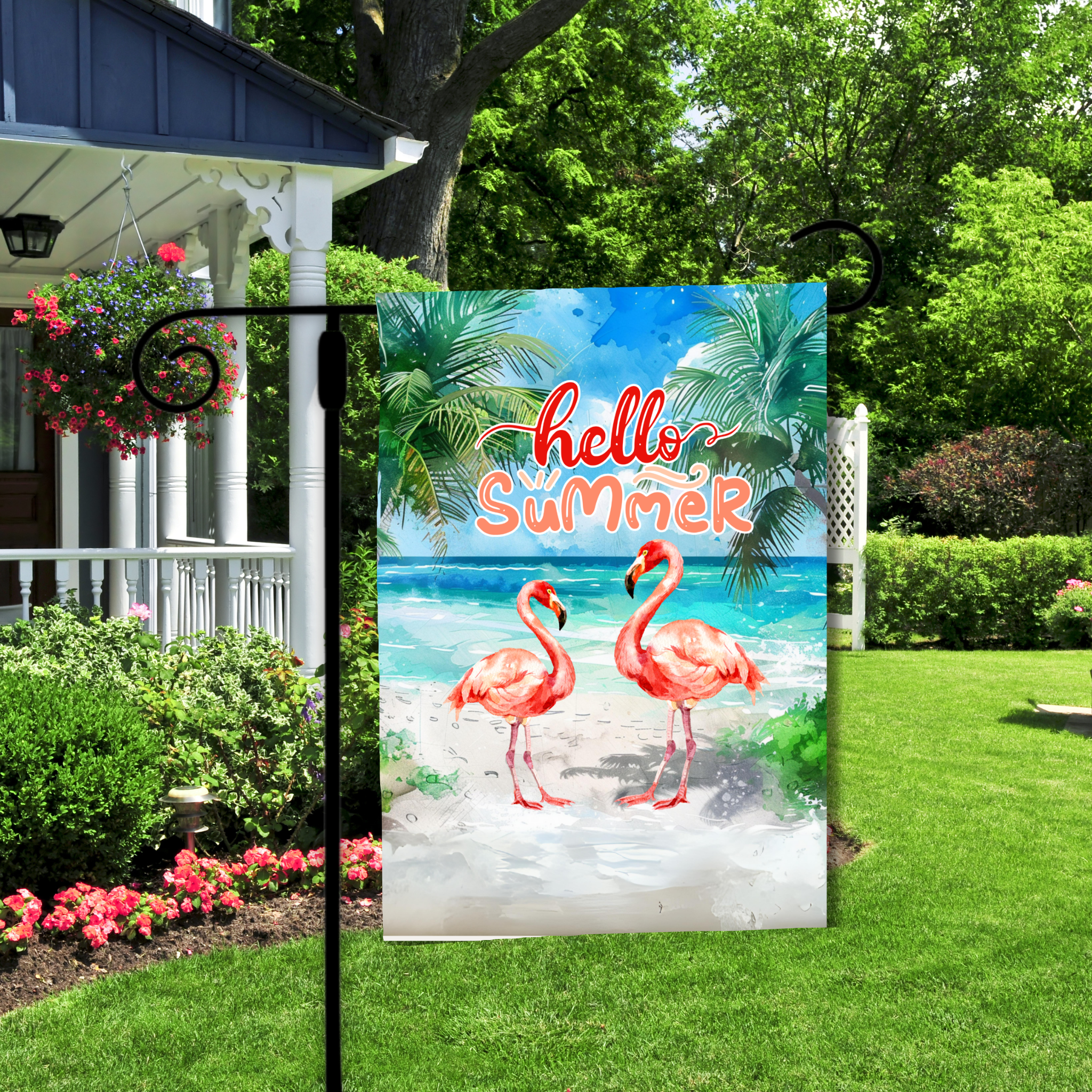 Garden flag with flamingos and 'hello Summer' text in a garden setting.