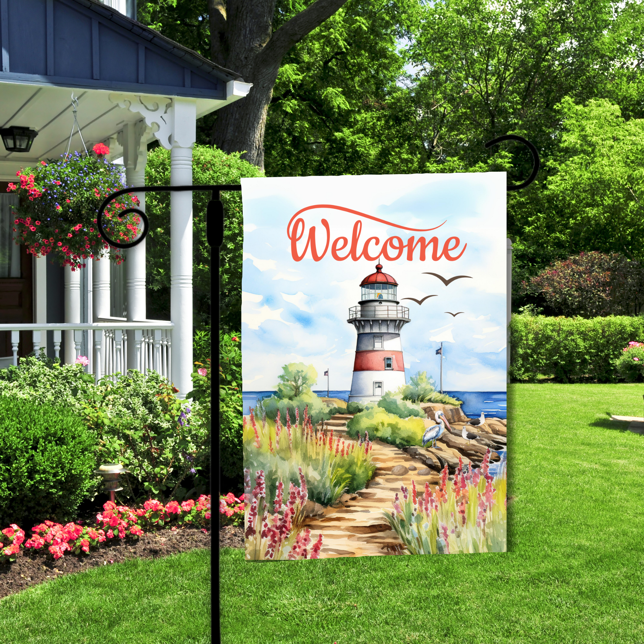 Decorative garden flag with a lighthouse design and 'Welcome' text, displayed outdoors.