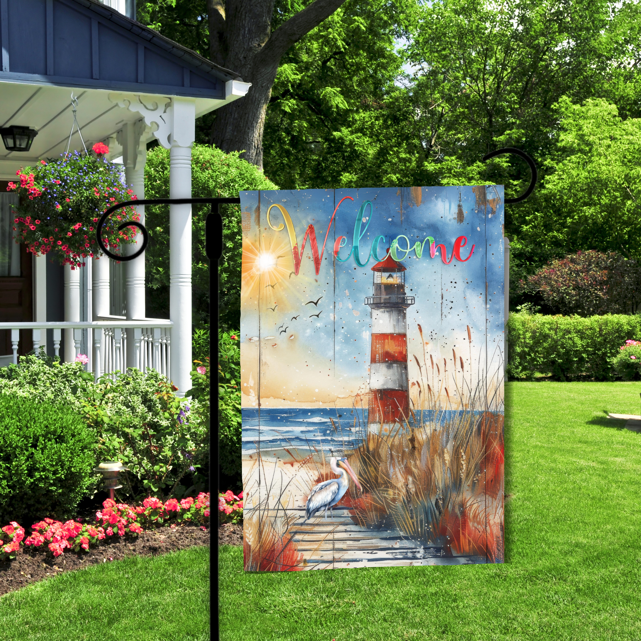 Decorative garden flag with a lighthouse design and 'Welcome' text, displayed outdoors.