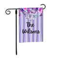 Decorative garden flag with floral design and 'The Wilsons' text on a purple and white striped background.